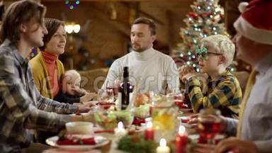 当一家人在圣诞<strong>餐桌</strong>旁聊天时，女人把馅饼端上<strong>餐桌</strong>